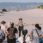 Group of tourists with a guide exploring White Sands National Park during daytime.